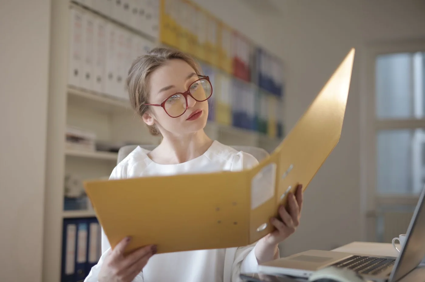 A woman reading documents at her desk.