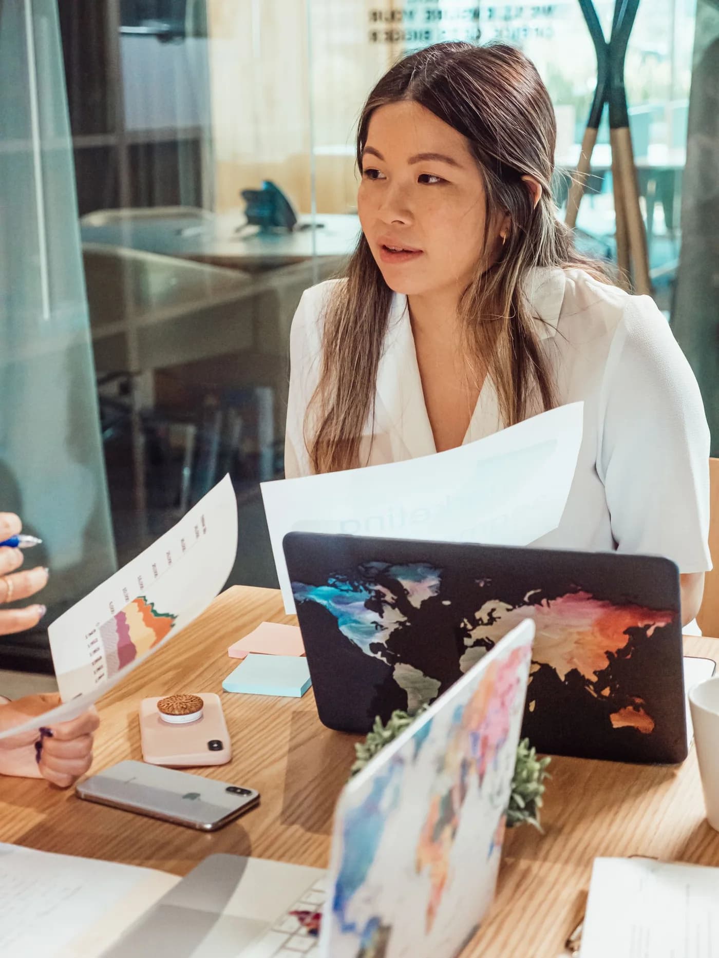 A woman coordinating work with colleagues around a meeting table.